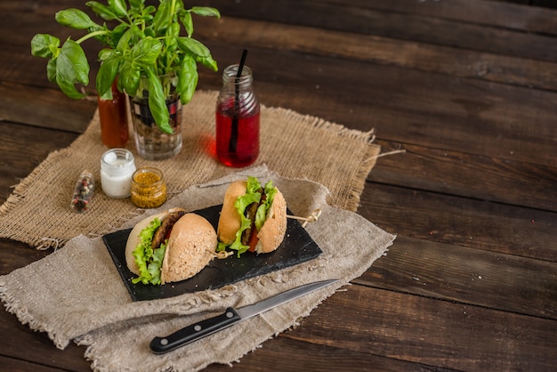 Sabrosa hamburguesa con carne y verduras sobre un fondo oscuro