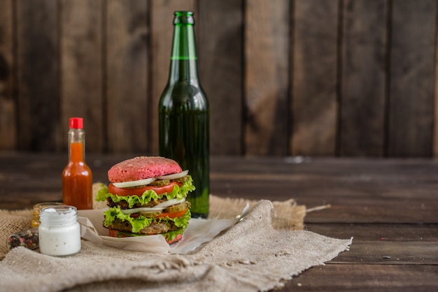 Sabrosa hamburguesa con carne y verduras sobre un fondo oscuro