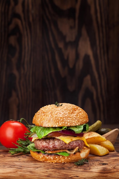 Sabrosa hamburguesa casera a la parrilla con carne de res, tomate, queso, pepino y lechuga. Con espacio para su texto