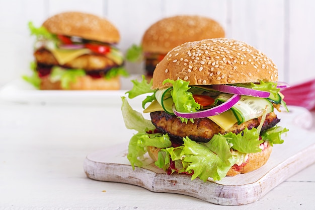 Sabrosa hamburguesa casera a la parrilla con hamburguesa de pollo, tomate, queso, pepino, lechuga y remolacha. Emparedado. Almuerzo