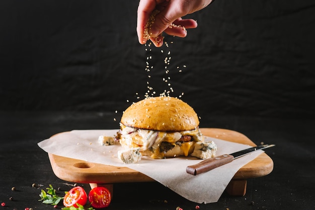 Foto sabrosa hamburguesa de comida rápida sobre fondo negro