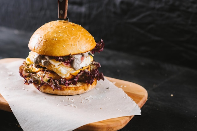 Sabrosa hamburguesa de comida rápida sobre fondo negro