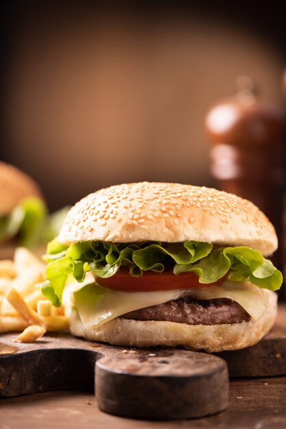 Una sabrosa hamburguesa fresca y papas fritas en la mesa de madera