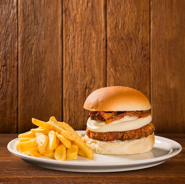 Sabrosa hamburguesa con queso y tocino en placa de madera