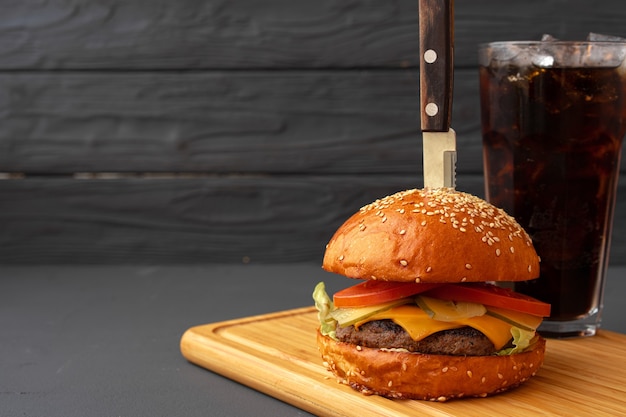 Sabrosa hamburguesa sobre fondo de madera negra de cerca