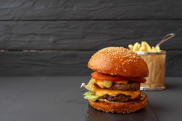 Sabrosa hamburguesa sobre fondo de madera negra de cerca