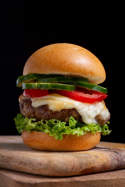 Sabrosa hamburguesa en tablero de madera