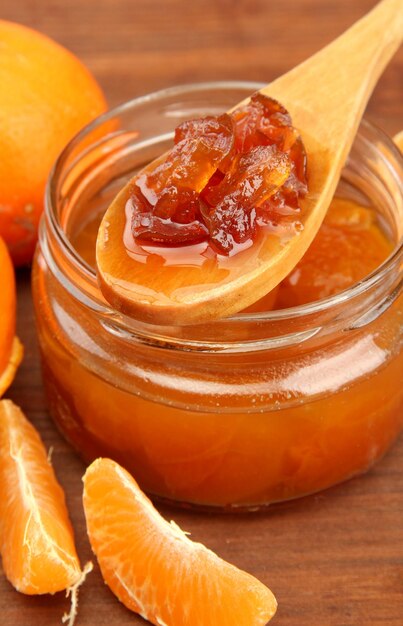 Sabrosa mermelada casera de mandarina sobre mesa de madera
