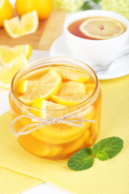 Sabrosa mermelada de limón con una taza de té en el primer plano de la mesa