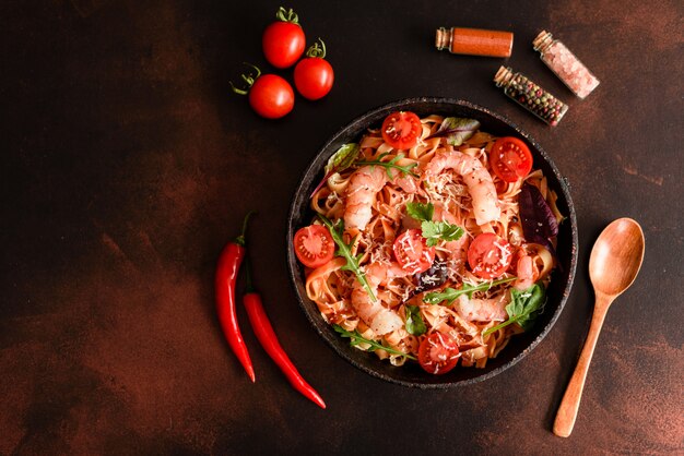 Sabrosa pasta con camarones y tomate en una sartén.