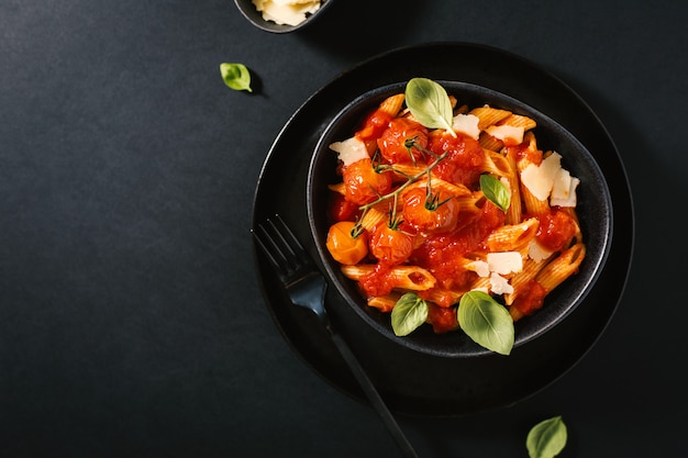 Sabrosa pasta de tomate en un tazón en la oscuridad