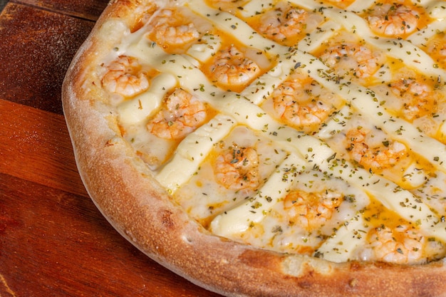 Sabrosa pizza de camarones con queso crema sobre un fondo de madera en Brasil se llama camarones