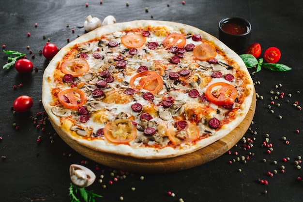 Sabrosa pizza de carne con varios ingredientes sobre fondo negro