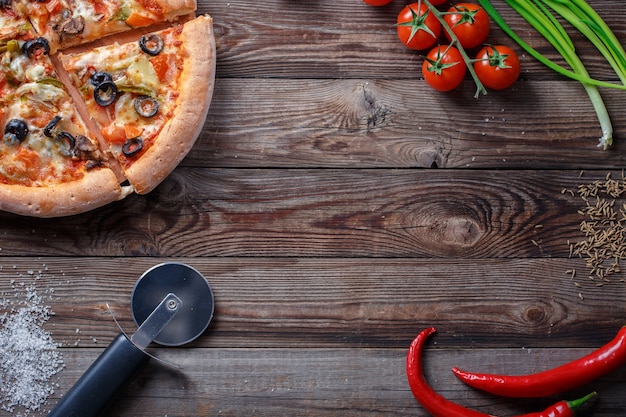 Sabrosa pizza con ingredientes sobre una tabla de madera. Vista superior con espacio vacío en el centro.