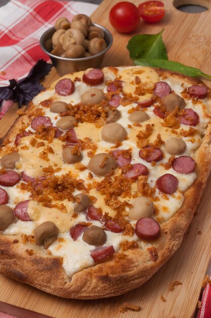 Foto sabrosa pizza italiana con salchichas, champiñones y mozzarella.