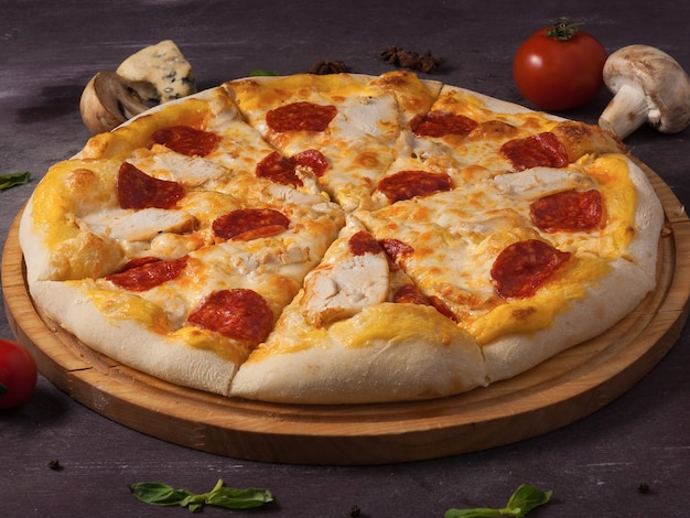 Sabrosa pizza con pechuga de pollo pepperoni y queso mozzarella sobre una tabla de madera