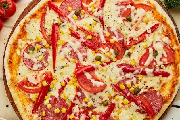 Sabrosa pizza de pepperoni recién horneada con salami queso mozzarella maíz y pimienta servida sobre fondo de madera con salsa de tomate y hierbas Concepto de entrega de alimentos Menú del restaurante