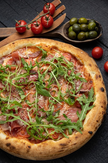 sabrosa pizza con queso y verduras en una mesa oscura de madera