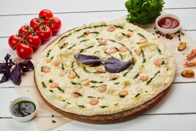 Sabrosa pizza recién horneada con gambas y queso mozzarella servida sobre fondo de madera con salsa de tomate y hierbas Concepto de entrega de alimentos Menú del restaurante