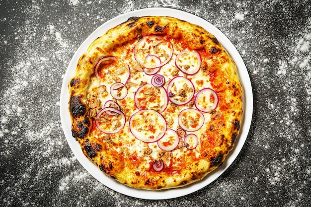 Foto sabrosa pizza tradicional caliente con atún sobre fondo oscuro