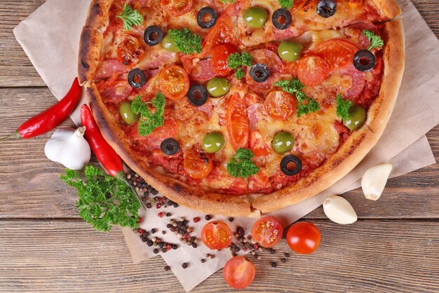 Sabrosa pizza con verduras de salchicha y ají sobre fondo de mesa de madera