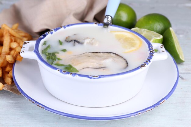 Sabrosa sopa con ostras en mesa de madera