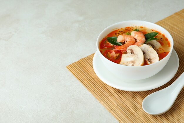 Sabrosa sopa Tom yum sobre estera de bambú