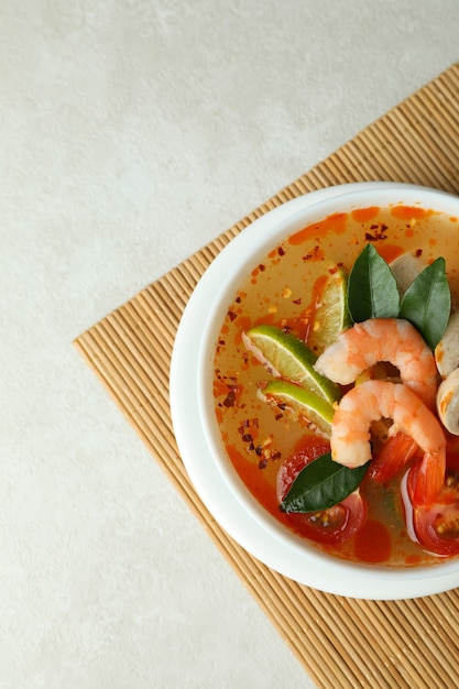 Sabrosa sopa Tom yum sobre estera de bambú