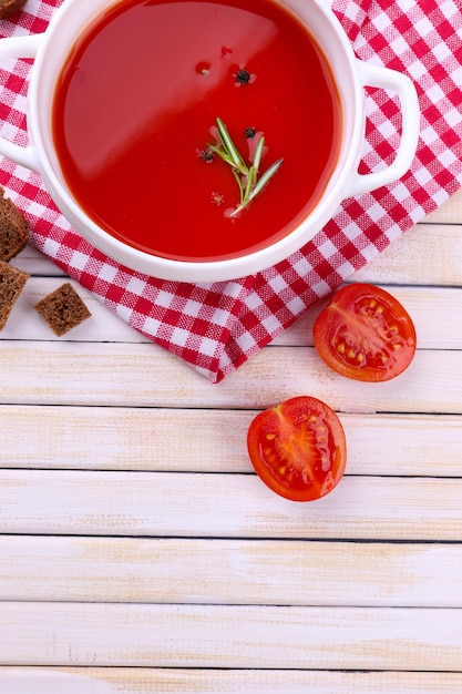 Sabrosa sopa de tomate en mesa de madera