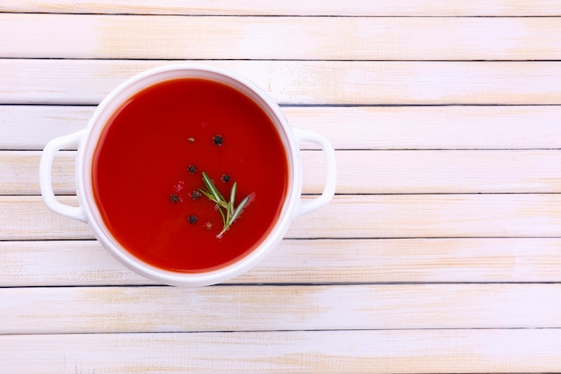 Sabrosa sopa de tomate en mesa de madera