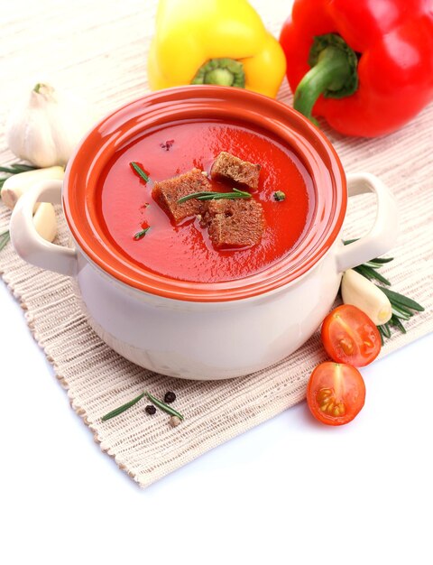 Sabrosa sopa de tomate y verduras aisladas en blanco