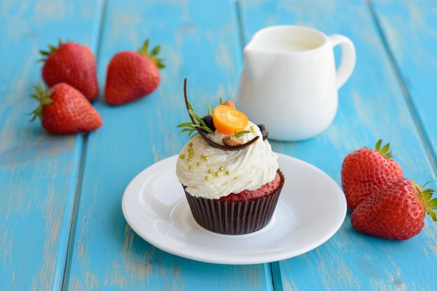 Sabrosa tarta con trozos de frutas y fresa en una mesa