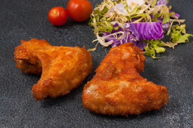 Sabrosas alitas de pollo empanizadas sobre un fondo oscuro