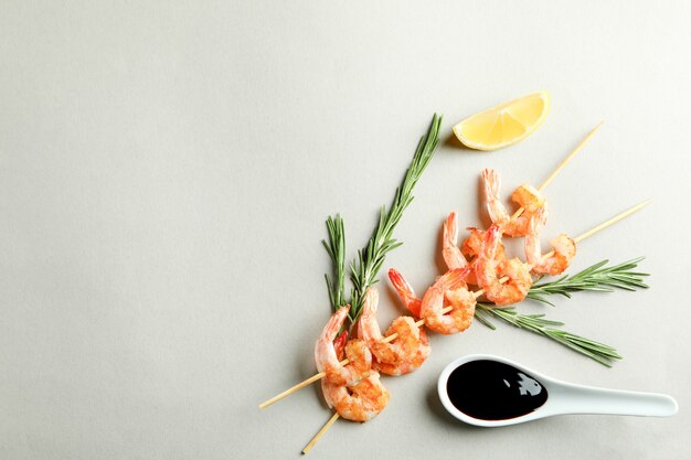 Sabrosas brochetas de camarones a la parrilla sobre fondo gris