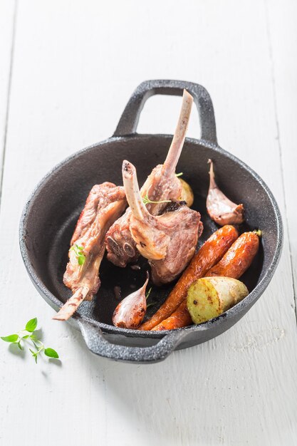 Sabrosas costillas de cordero a la parrilla sobre una vieja mesa blanca