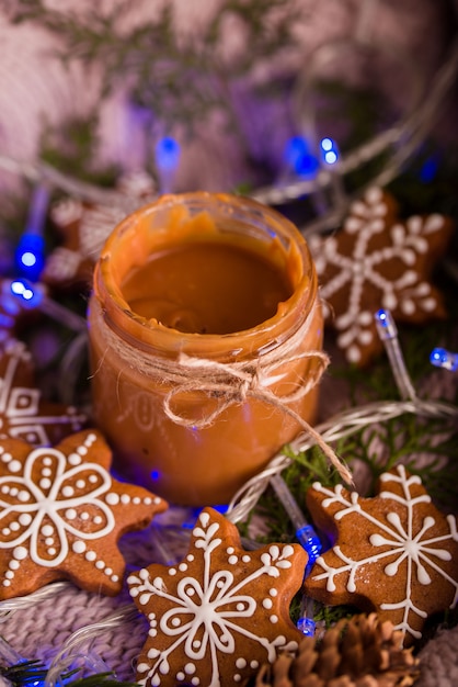 Las sabrosas y fragantes galletas de chispas de chocolate se trituran con azúcar en polvo, con luces multicolores sobre la mesa. Feliz Navidad