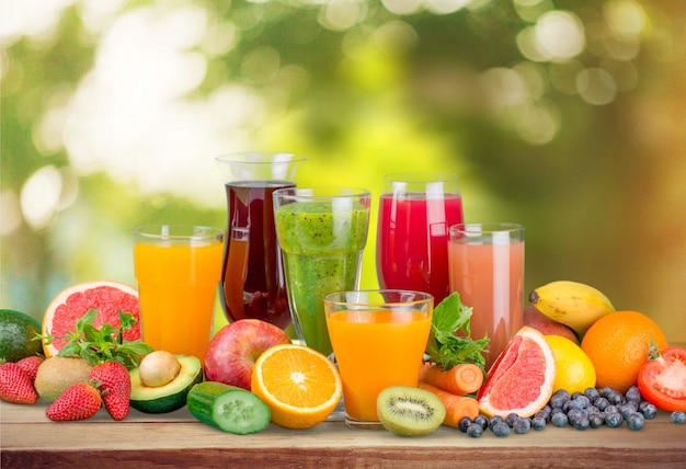 Foto sabrosas frutas y jugos con vitaminas en el fondo