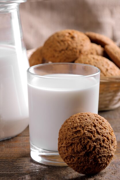 Sabrosas galletas de avena dulce con leche en una mesa de madera marrón. de cerca