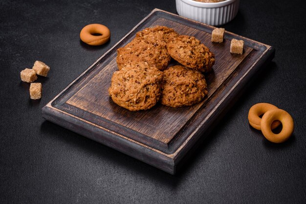 Sabrosas galletas de avena frescas sobre un fondo de hormigón oscuro Deliciosos dulces saludables