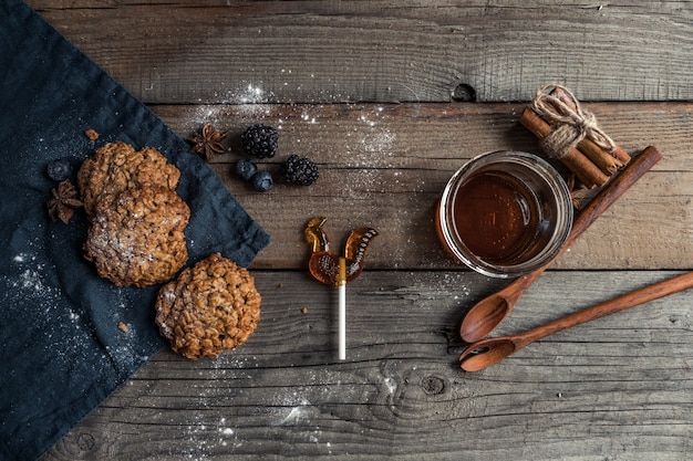 Foto sabrosas galletas caseras con cucharas de especias y caramelos rizados sobre una mesa de madera