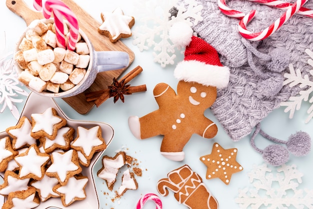 Sabrosas galletas de jengibre y decoración navideña sobre fondo pastel.