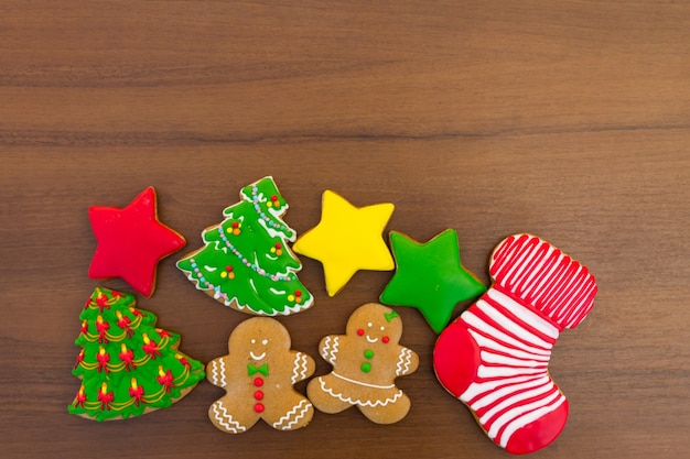 Sabrosas galletas de Navidad festivas en forma de árbol de Navidad, hombre de jengibre, estrella y calcetín de Navidad en la mesa de madera. Vista superior