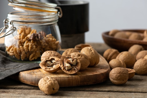 Sabrosas nueces con cáscaras de nuez divididas agrietadas en la mandíbula sobre una servilleta rústica y mesa de madera