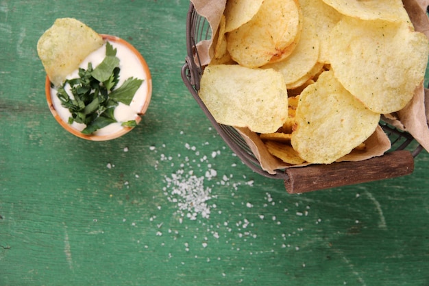 Sabrosas patatas fritas en una cesta de metal sobre una mesa de madera