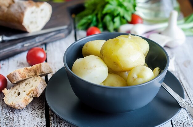 Sabrosas patatas hervidas con eneldo, sparsley y cebollas en un tazón negro