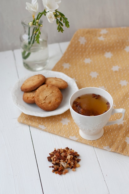 Foto sabroso aperitivo taza de té y un plato de galletas.