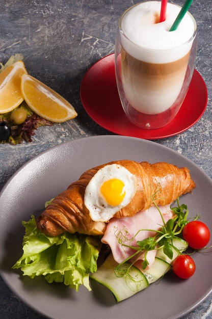 Sabroso croissant con jamón y café con leche Concepto Desayuno