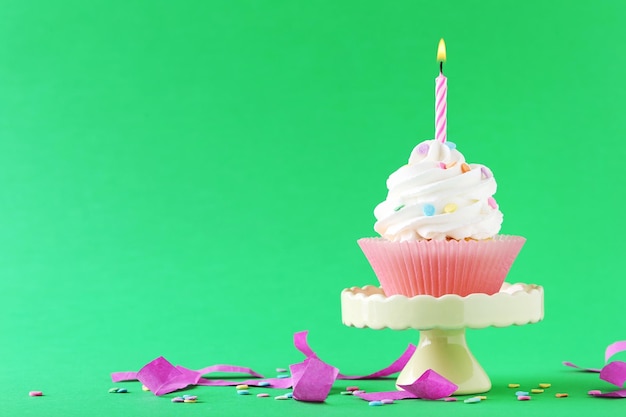 Sabroso cupcake con velas sobre un fondo verde