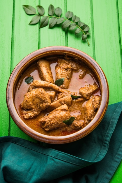 Sabroso curry de pescado servido con arroz basmati cocido blanco con hojas de curry en el fondo, comida india costera favorita