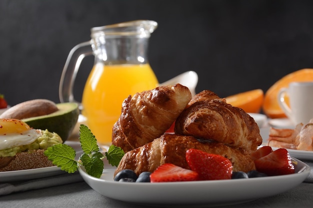 Sabroso desayuno Croissants frutas frescas y secas jugo fresco